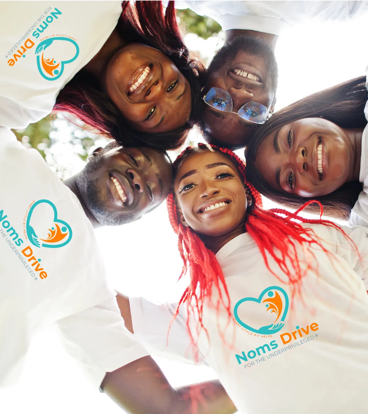 Group of diverse volunteers smiling together representing community outreach and support by Noms Drive South Africa