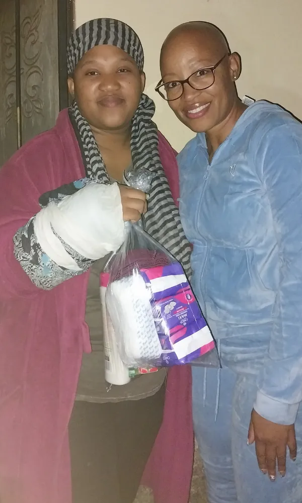 Woman receiving sanitary and hygiene products from Noms Drive initiative South Africa