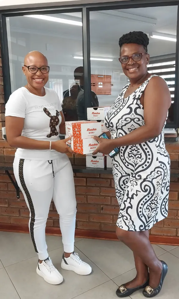 Noms Drive team handing over school shoes to community members in South Africa